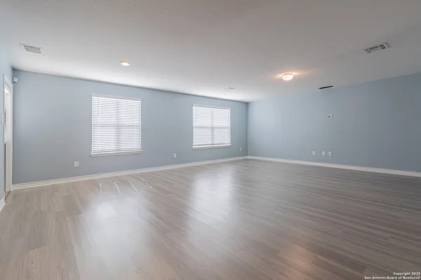 an empty room with wooden floor and window