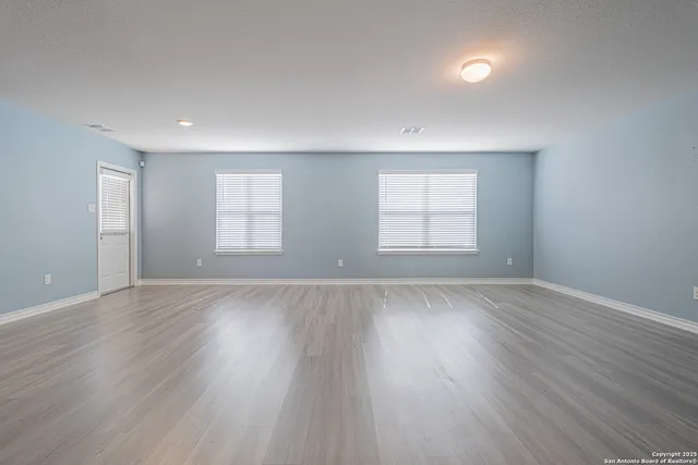 an empty room with wooden floor and window
