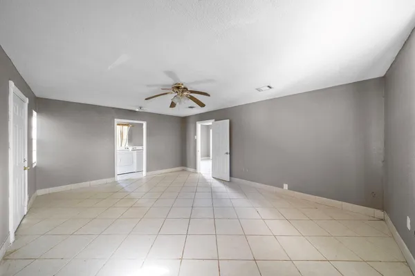 a view of an empty room with a chandelier fan