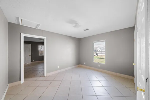 a view of an empty room with window and closet area