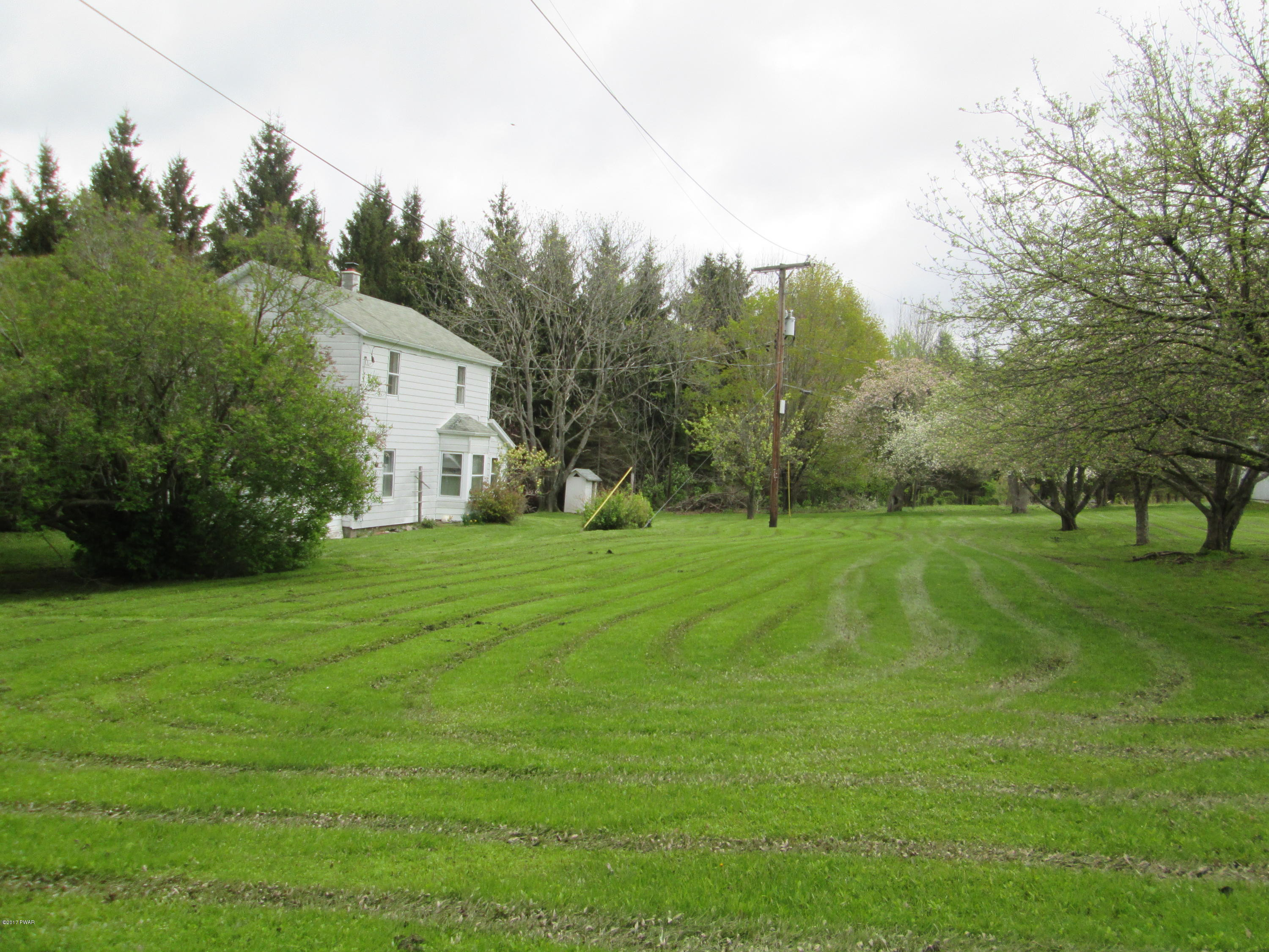 86 Beaver Hollow Road Lakewood, PA 18439 - Photo 30 of 30 a view of a white house that has a big yard with wooden fence