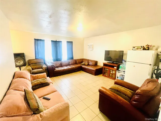a living room with furniture a air conditioner and a flat screen tv