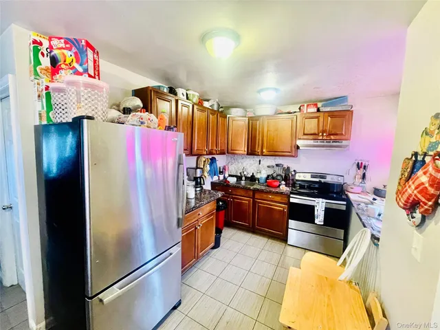 a kitchen with stainless steel appliances granite countertop a refrigerator and a stove