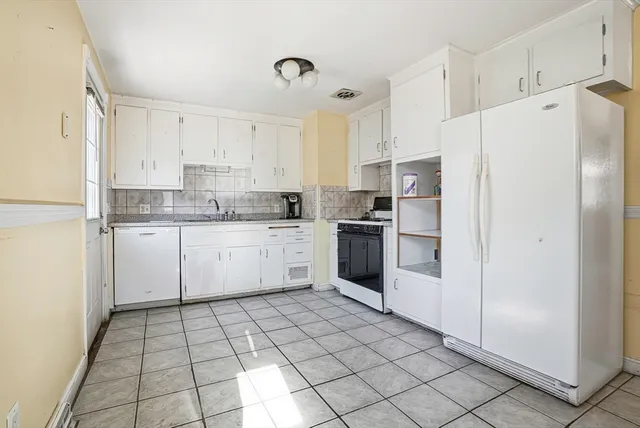 a backyard of a house with barbeque oven table and chairs