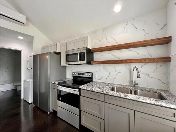 a kitchen with stainless steel appliances granite countertop a sink stove and refrigerator