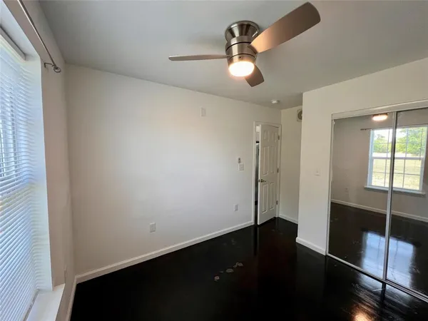 a view of empty room with wooden floor