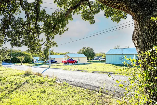 a view of a house with a big yard and large trees