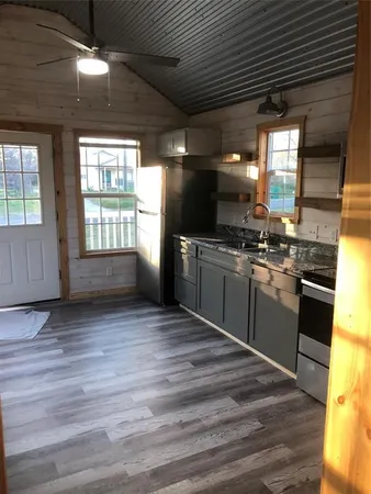 a kitchen with stainless steel appliances granite countertop a sink a stove and a wooden floors