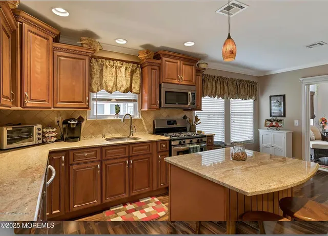 a kitchen with granite countertop a sink appliances and cabinets