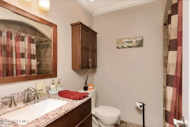 a bathroom with a granite countertop sink mirror vanity and toilet