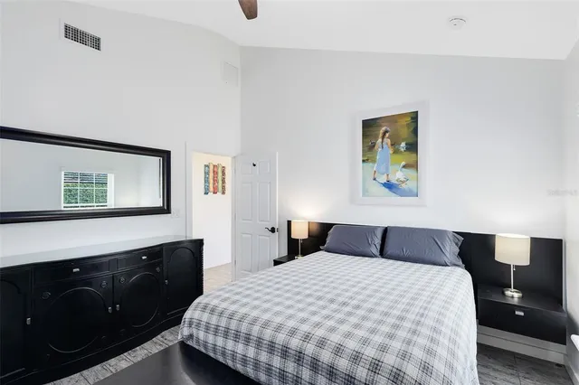 a bedroom with a bed and painting on the wall