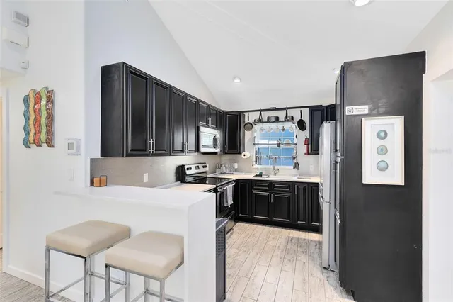 a kitchen with stainless steel appliances a stove refrigerator sink and cabinets