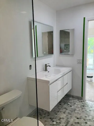 a bathroom with a sink a toilet and mirror