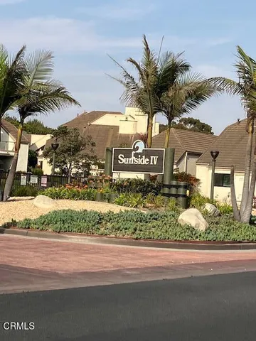 a view of a house with a yard and potted plants