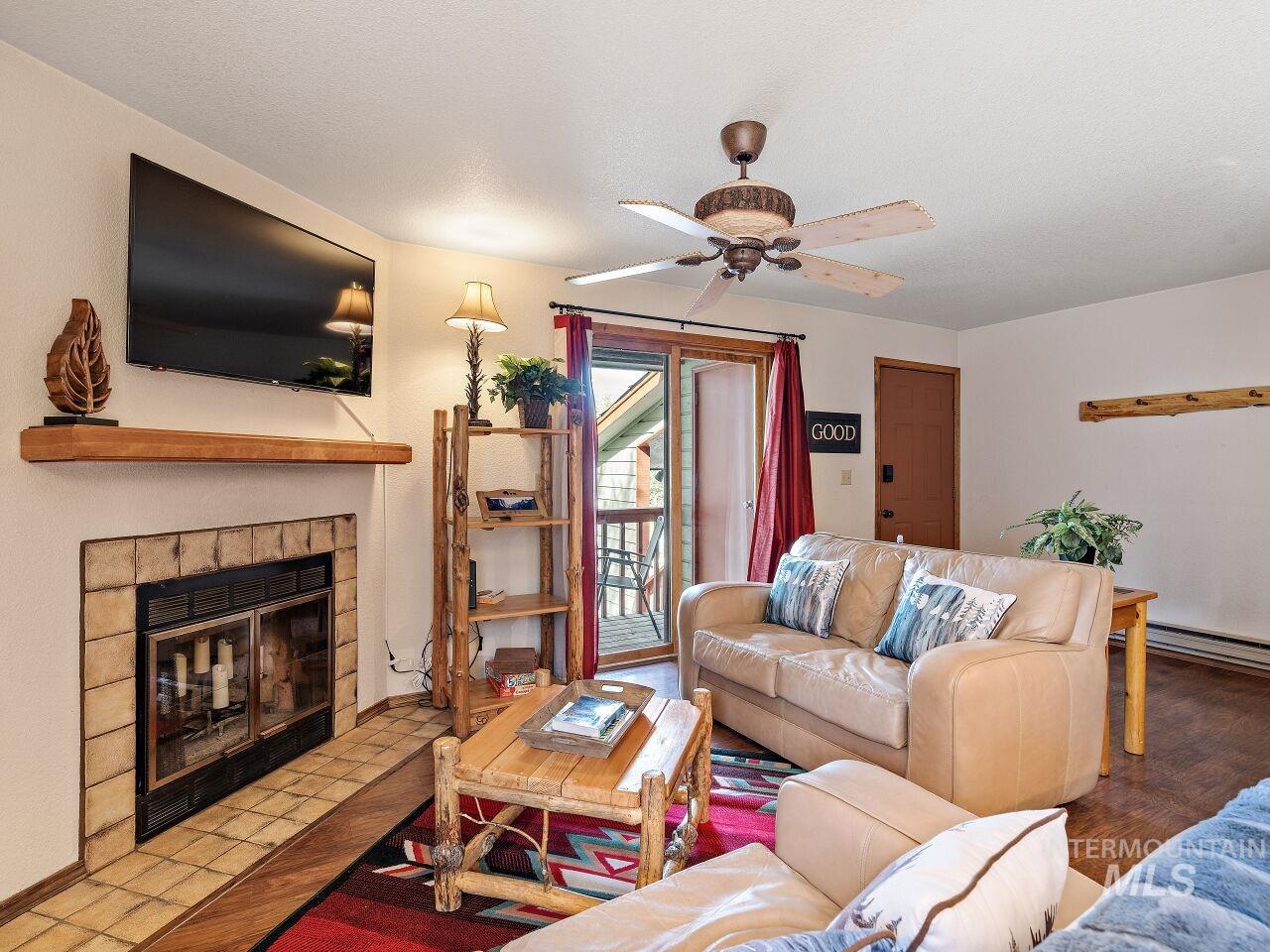 601 Hemlock Street, Unit 10 McCall, ID 83638 - Photo 15 of 43 Living area featuring a tiled fireplace and ceiling fan