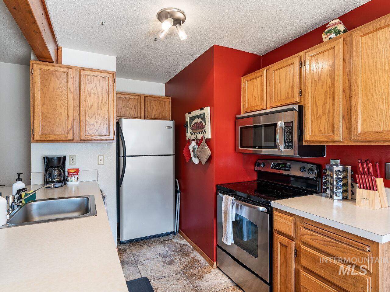 601 Hemlock Street, Unit 10 McCall, ID 83638 - Photo 21 of 43 Kitchen with appliances with stainless steel finishes, light countertops, and a textured ceiling