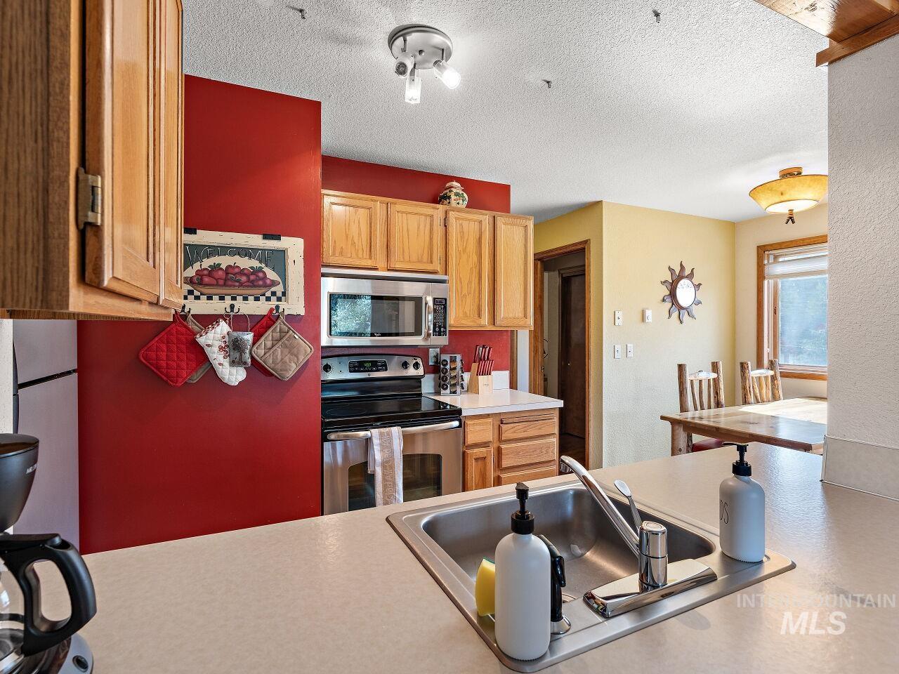 601 Hemlock Street, Unit 10 McCall, ID 83638 - Photo 24 of 43 Kitchen featuring stainless steel appliances, light countertops, and a textured ceiling
