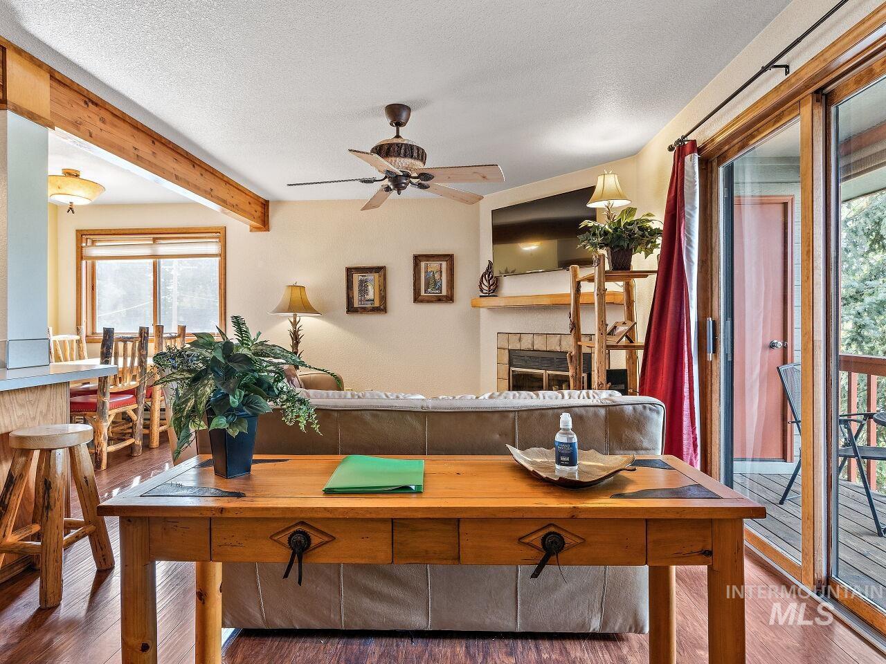 601 Hemlock Street, Unit 10 McCall, ID 83638 - Photo 26 of 43 Living Room featuring wood finished floors, a ceiling fan, plenty of natural light, beam ceiling, and a textured ceiling