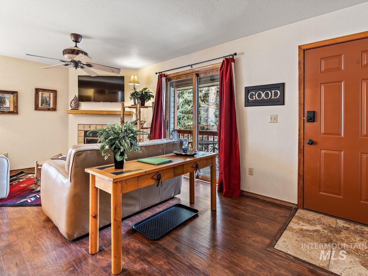 601 Hemlock Street, Unit 10 McCall, ID 83638 - Photo 6 of 43 Living room with wood finished floors, a ceiling fan, and a tiled fireplace