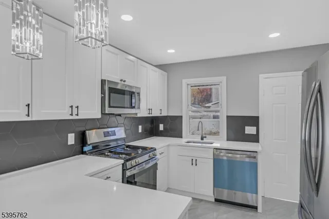 a kitchen with stainless steel appliances a stove microwave and refrigerator