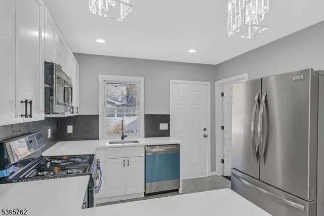 a kitchen with stainless steel appliances a refrigerator sink and stove