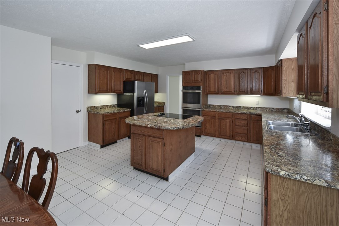 30776 Cedar Road Cleveland, OH 44124 - Photo 7 of 41 Kitchen featuring light tile patterned floors, a kitchen island, and stainless steel appliances
