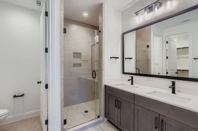 a bathroom with double sink and a mirror