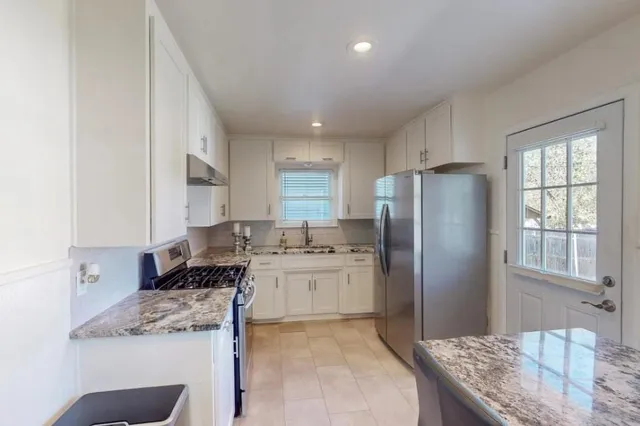 a kitchen with a stove a refrigerator and a sink
