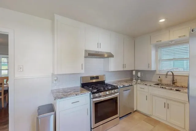 a kitchen with granite countertop white cabinets and white appliances