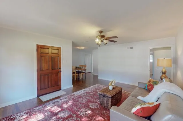 a living room with furniture and wooden floor