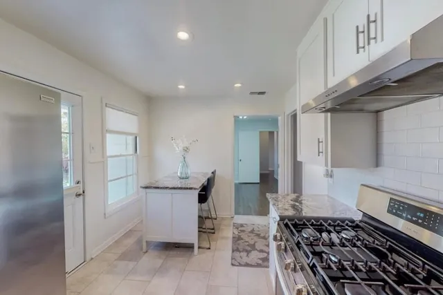 a kitchen with stainless steel appliances granite countertop a refrigerator and a stove