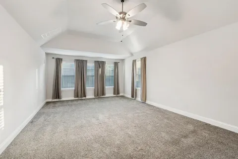 a view of a big room with chandelier fan and windows