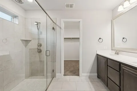 a bathroom with a shower sink and mirror
