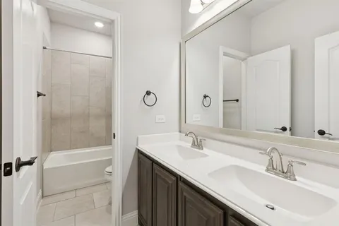 a bathroom with a bath tub sink mirror and shower