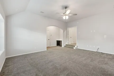 a view of an empty room with a chandelier fan