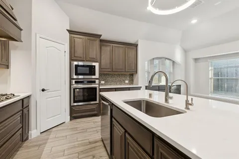 a kitchen with a sink and stainless steel appliances