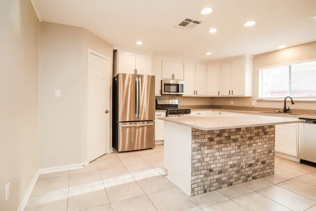 a kitchen with stainless steel appliances a refrigerator sink microwave and cabinets