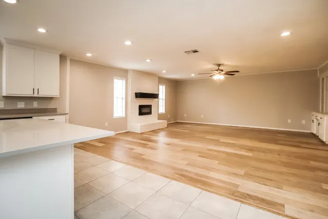 a view of an empty room with kitchen and kitchen view