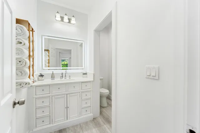a bathroom with a toilet sink and mirror