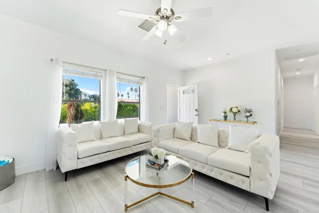 a kitchen with stainless steel appliances granite countertop a stove top oven a sink dishwasher a dining table and chairs with wooden floor