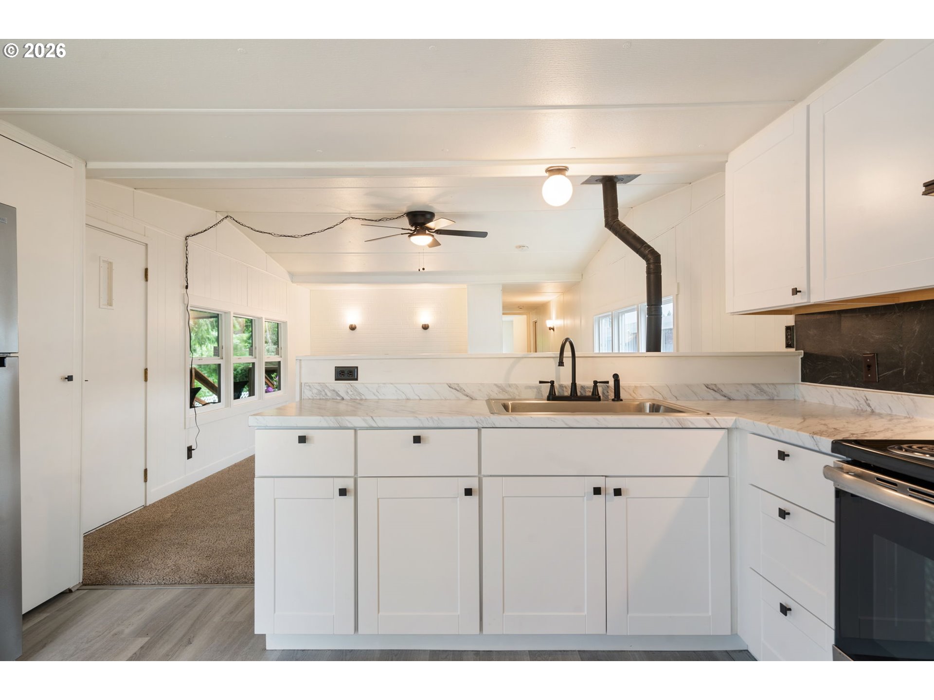15130 South Maplelane Road, Unit 50 Oregon City, OR 97045 - Photo 6 of 36 a kitchen with white cabinets a sink and dishwasher