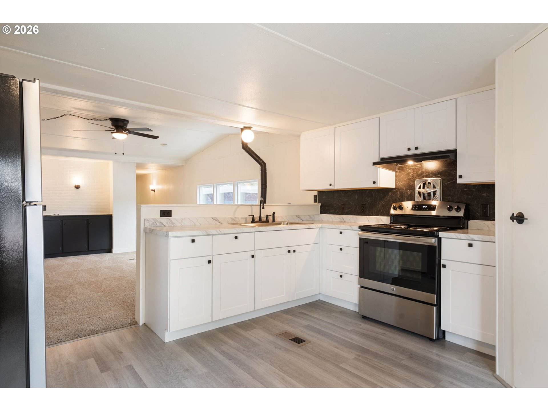 15130 South Maplelane Road, Unit 50 Oregon City, OR 97045 - Photo 8 of 36 a kitchen with granite countertop white cabinets and white appliances
