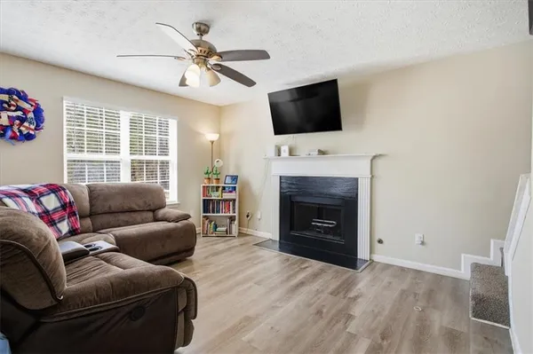 a living room with furniture a fireplace and a flat screen tv