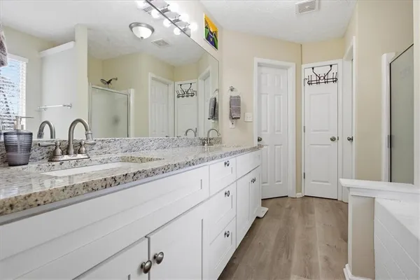 a bathroom with a sink double vanity granite tub and shower