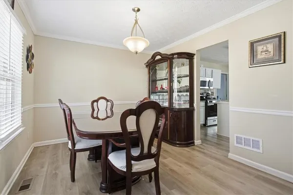 a table and chairs in a room next to a window