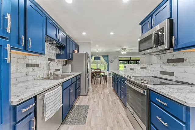 a kitchen with stainless steel appliances granite countertop a sink stove and cabinets