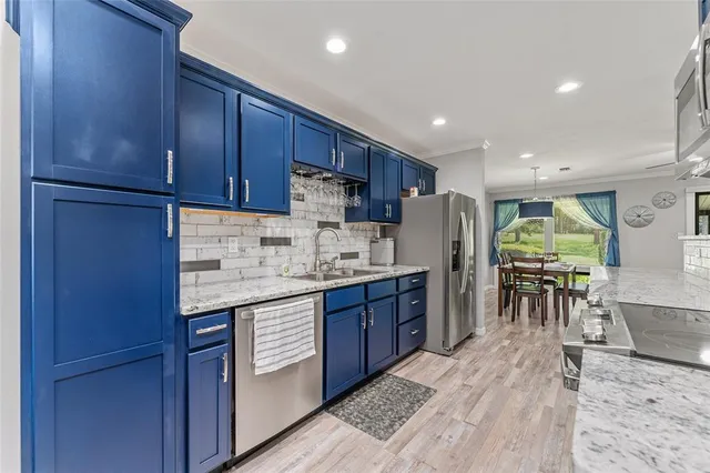 a kitchen with stainless steel appliances granite countertop a refrigerator sink and cabinets