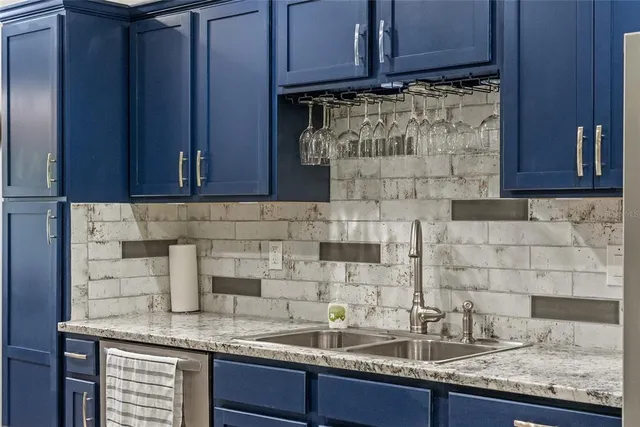a kitchen with granite countertop a sink a stove and cabinets
