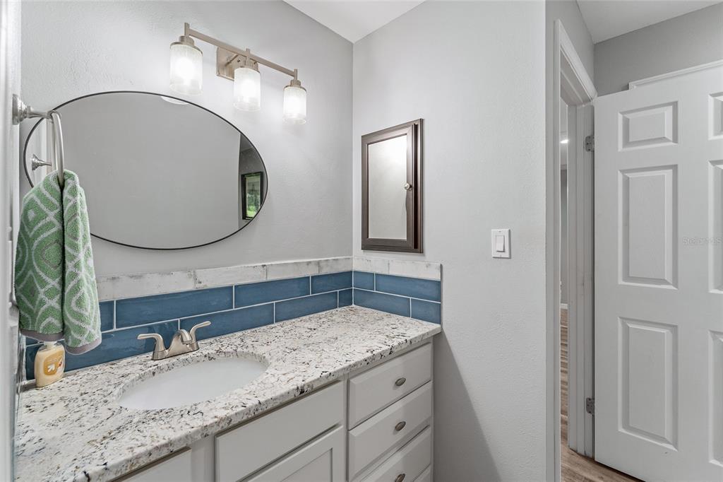 19660 Southwest 83rd Place Road, Unit C13 Dunnellon, FL 34432 - Photo 34 of 52 a bathroom with a granite countertop sink and a mirror