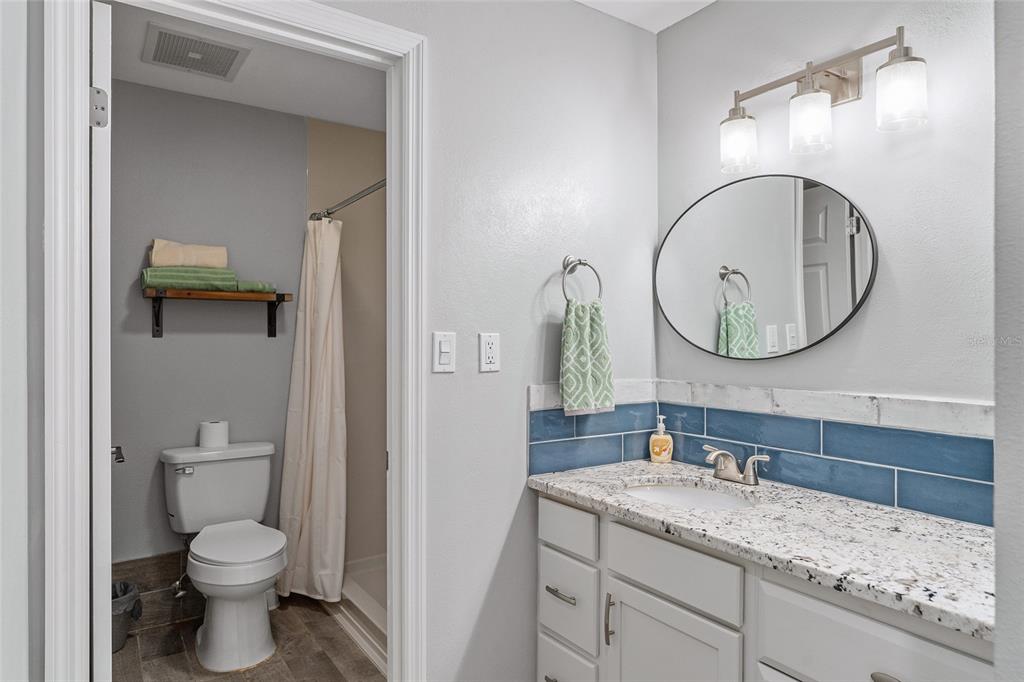 19660 Southwest 83rd Place Road, Unit C13 Dunnellon, FL 34432 - Photo 36 of 52 a bathroom with a granite countertop toilet sink and mirror